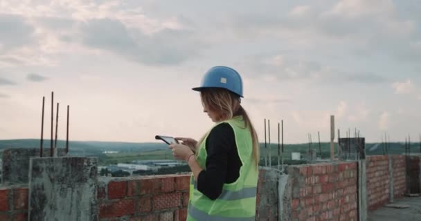 Woman expert engineer and group of builders analyzing the construction plan of building using tablet - Materiał filmowy, wideo