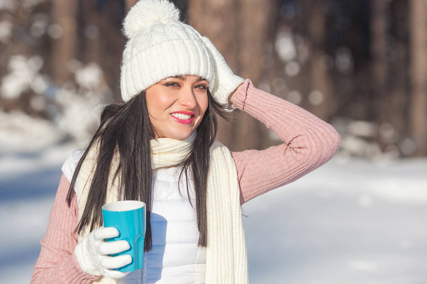 Beautiful lady with coffee cup in winter time outdoors - Photo, Image
