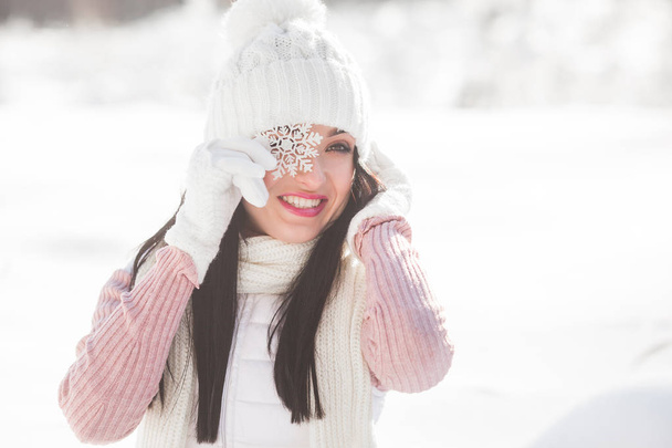 Close up portrait of young beautiful woman in the winter wood. Attractive lady smiling at camera - Photo, Image
