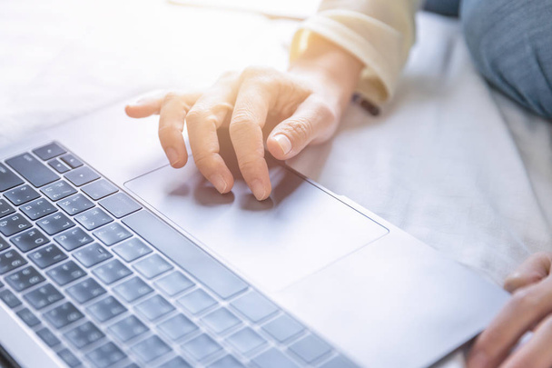 Мягкая сцена женской руки поиск данных в Интернете с ноутбука компьютера в домашнем офисе
. - Фото, изображение