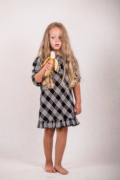 belle petite fille mignonne manger de délicieuses bananes saines sur fond blanc
 - Photo, image