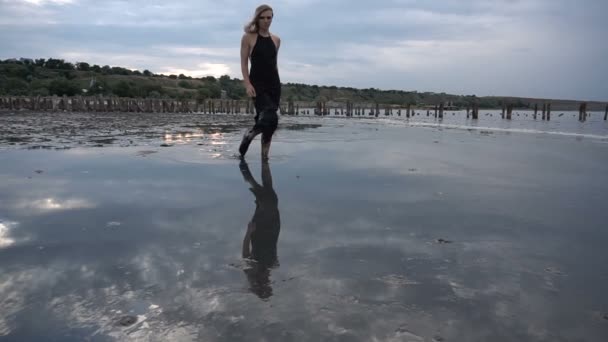 Adorable Slender Blonde Walk by Flat Surface of Shallow Salt Firth with Healthy Black Mud. - Footage, Video