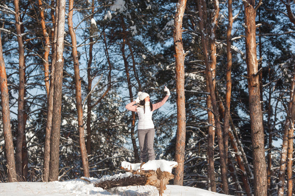 Młoda kobieta próbuje znaleźć połączenia mobilnego w zimowym drewnem - Zdjęcie, obraz