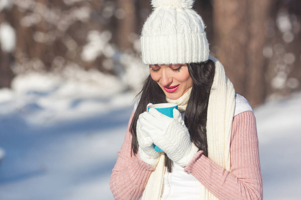 Jonge aantrekkelijke vrouw drinken koffie buiten in de winter - Foto, afbeelding
