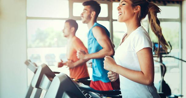 Picture of people doing cardio training on treadmill in gym - Фото, зображення