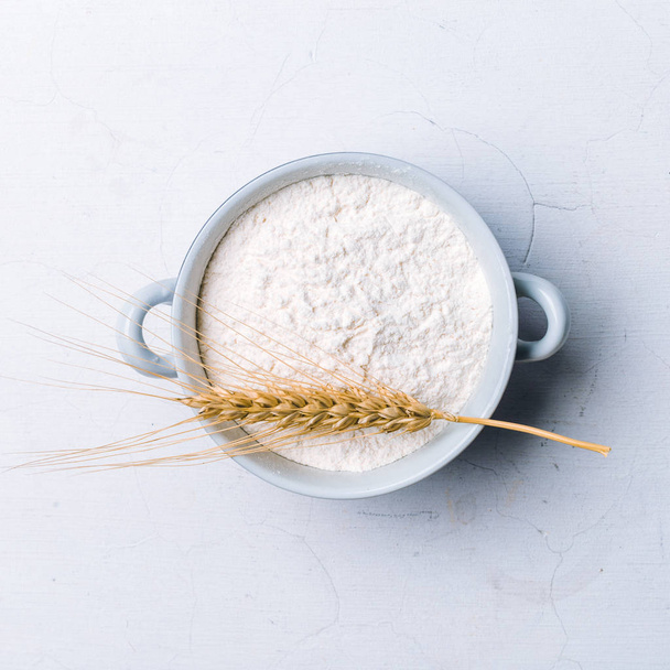 Whole flour in bowl with wheat ears on white background - Foto, immagini