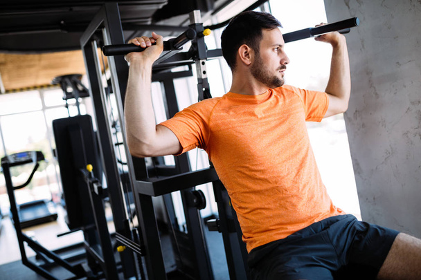 Man working out in gym on fitness machine - Valokuva, kuva