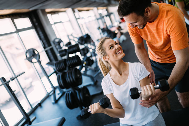 Working out in fitness center with trainer supervision - Fotoğraf, Görsel