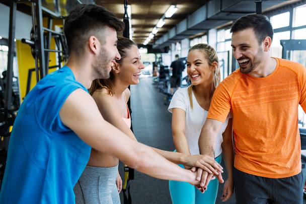 Happy fitness class giving high-five after completing exercise session. Smiling friends celebrate their success. - Fotoğraf, Görsel