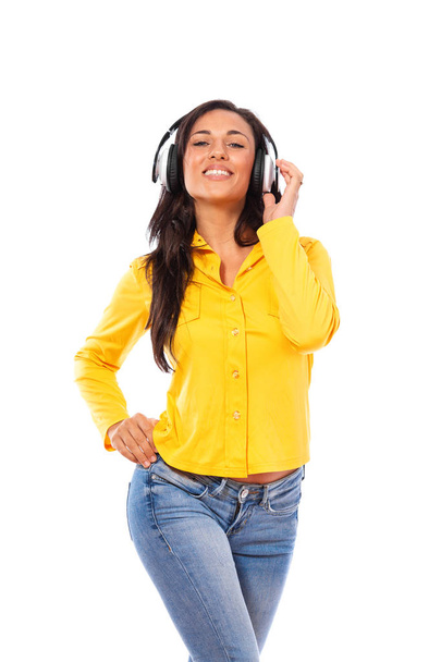 Счастливая молодая женщина слушает музыку на стерео наушниках и сияющая улыбка удовольствия изолированы на белом
 - Фото, изображение