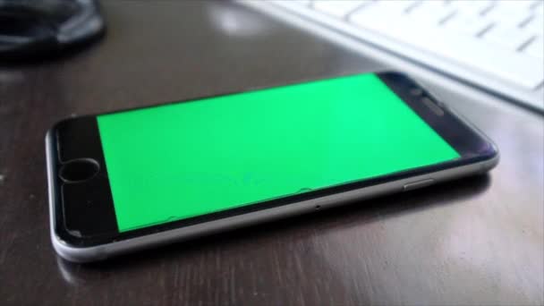 smartphone con pantalla verde en blanco sobre mesa de madera en casa
 - Imágenes, Vídeo