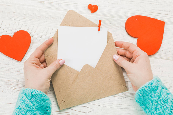 Hand eines Mädchens, das am Valentinstag Liebesbriefe schreibt. Handgefertigte Postkarte mit roter Herzfigur. 14 februar feiertag. Valentinstag-Konzept mit Kopierraum. - Foto, Bild