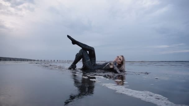 Adorable Slender Blonde Lays Smeared in a Black Mud looks like Petroleum Oil - Footage, Video