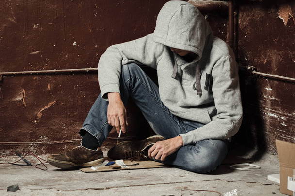 Uomo tossicodipendente con una siringa in azione. Il concetto di abuso e traffico di droga
. - Foto, immagini