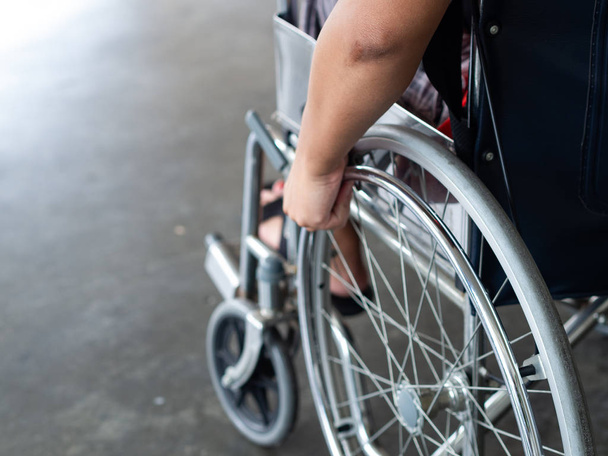 Un discapacitado está sentado en una silla de ruedas. Él sostiene sus manos en el volante. Personas discapacitadas Concepto
. - Foto, Imagen
