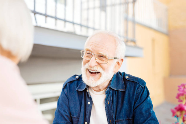 Cheerful senior man talking to wife - Foto, afbeelding