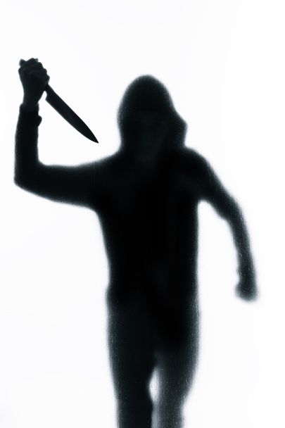 彼の手でナイフで曇らされたガラスの後ろに危険な男。ハロウィーン。黒と白のイメージ - 写真・画像