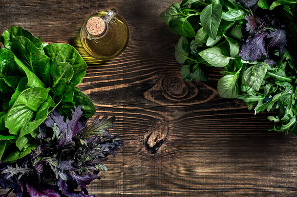 Variety of fresh organic herbs on wooden background. Freshly harvested herbs including basil, arugula. Top view. Copy space. - Foto, imagen