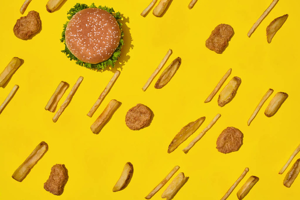 Repas de restauration rapide le plus populaire. Nuggets de poulet, hamburger et frites sur fond jaune vue du dessus
 - Photo, image