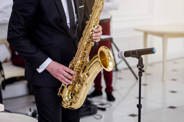 Золотой саксофон с пятнами на руках
  - Фото, изображение