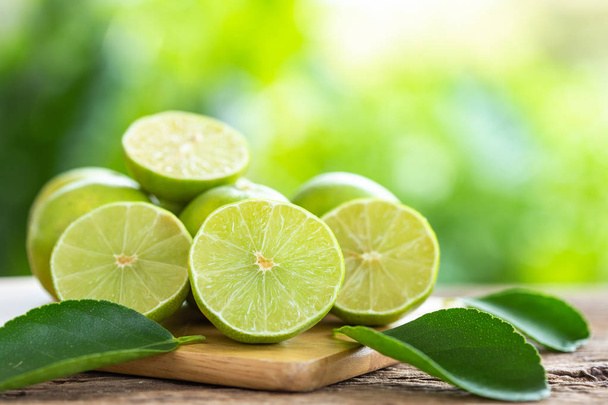 Close up slice green fresh lemon on wooden table background - Fotó, kép
