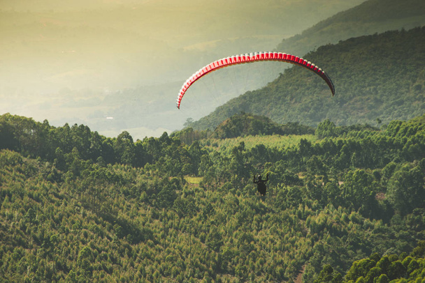 Parapente volando sobre el hermoso cielo soleado sobre las verdes montañas de Poos de Caldas, Minas Gerais
 - Foto, imagen