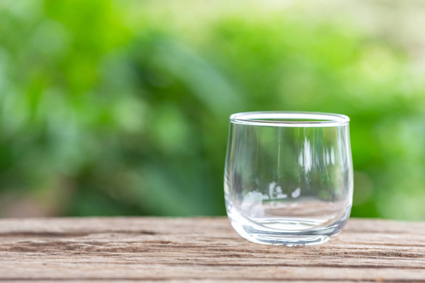 Cerrar vaso de beber vacío en la mesa de madera con fondo difuminado espacio para el texto
 - Foto, Imagen