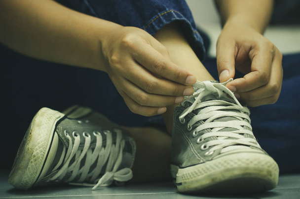 Жінки сидять на підлозі і плетуть кросівки. Поняття подорожей або пригод
. - Фото, зображення