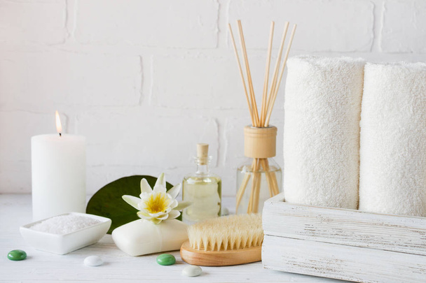 Wellness instelling en gezondheid zorg artikelen, Lichaamsolie, zeep, kaarsen, handdoek met lila bloem - Foto, afbeelding