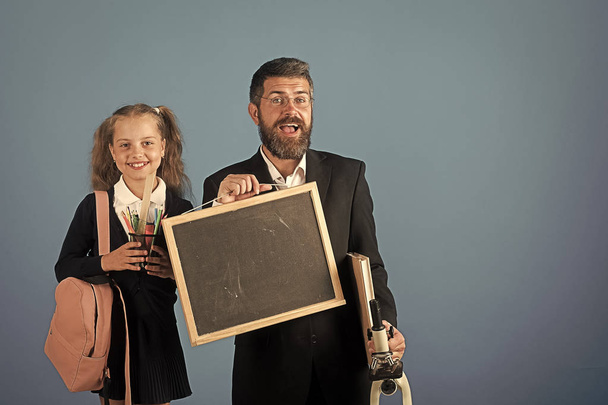 Kid and dad hold microscope, blackboard, book and stationery - Foto, imagen