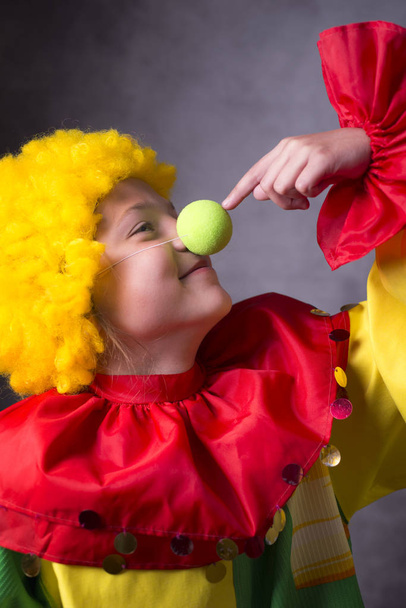 Fröhlicher kleiner Clown berührt eigene falsche Nase - Foto, Bild