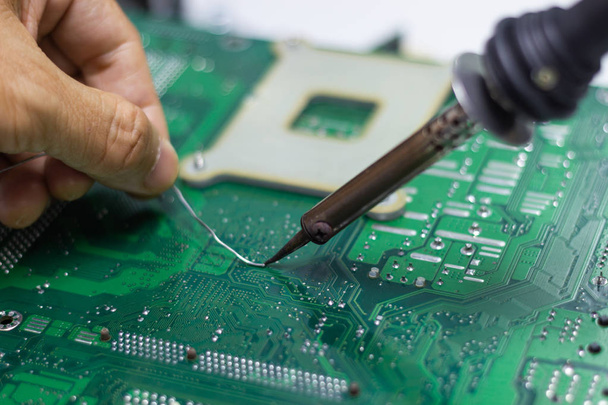 technician repairing electronic of the computer's circuit board by soldering Irons, concept  technology of computer circuit hardware - Photo, Image