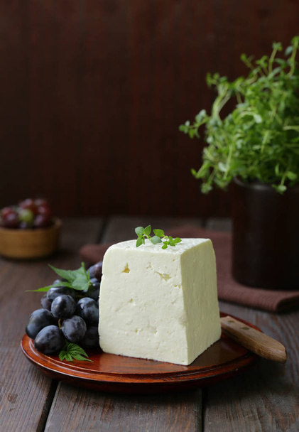 queso casero con uvas en una tabla de madera
 - Foto, imagen