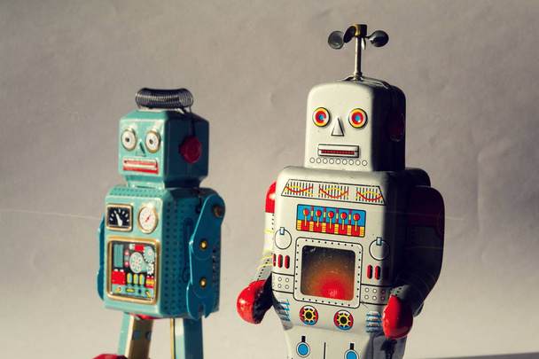 Két dühös vintage ón játék robotok, mesterséges intelligencia, robotika drone szállítás, mély gépi tanulás fogalma - Fotó, kép