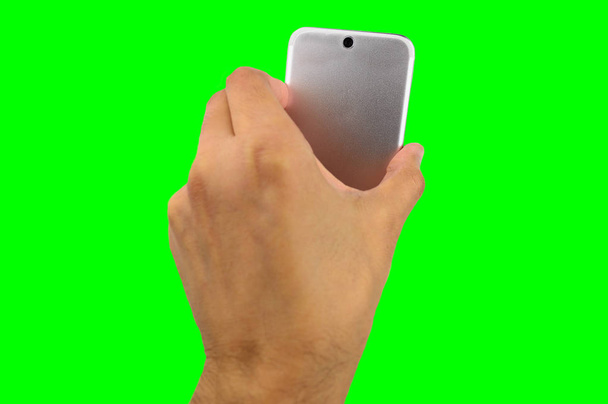 A hand holding up a back smart phone with a isolated cutout on green background with chroma key - Fotó, kép