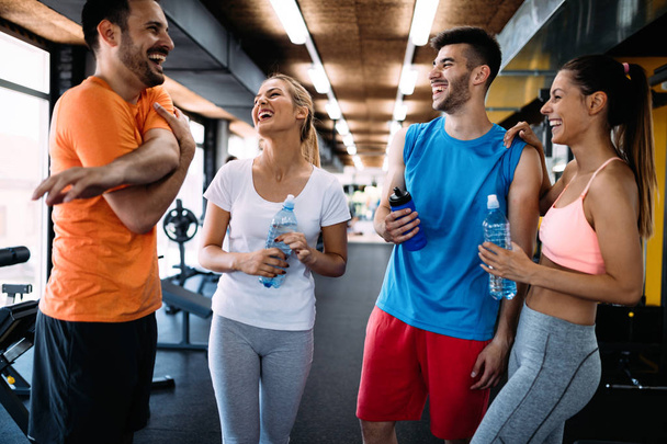 Picture of young cheerful fitness team in gym - Photo, image