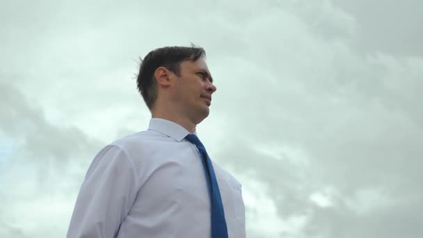 Σοβαρός επιχειρηματίας στην ισοπαλία εναντίον μπλε σύννεφο - Πλάνα, βίντεο