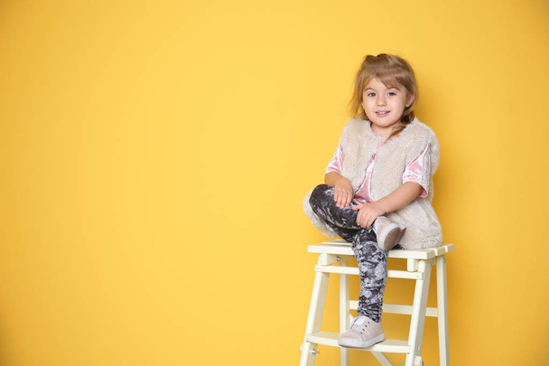 kleines Mädchen im trendigen Outfit auf farbigem Hintergrund - Foto, Bild