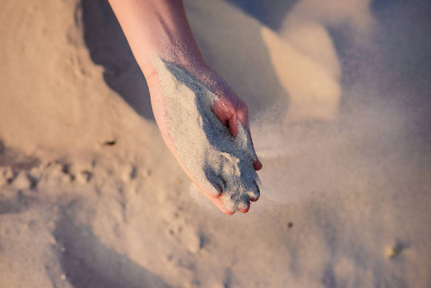 ženské ruce nasypat písek na zemi. - Fotografie, Obrázek
