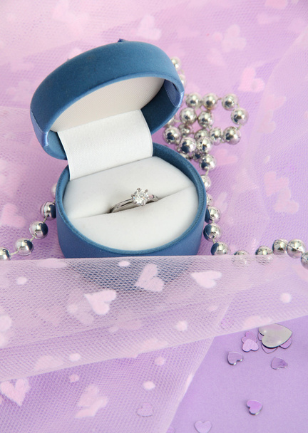Beautiful box with wedding ring on purple background - Фото, зображення