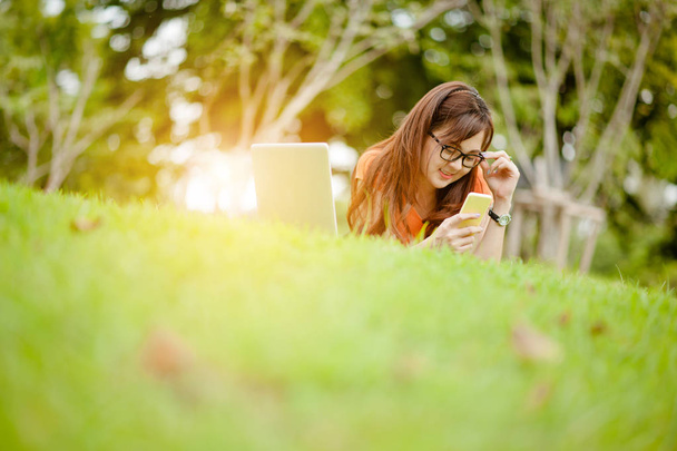 Young beautiful Asian woman working at outdoor park,happy relaxing. owner business woman work  at outdoor park.internet and technology concept. - Foto, afbeelding
