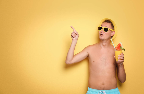 Shirtless man with glass of cocktail on color background - Фото, зображення