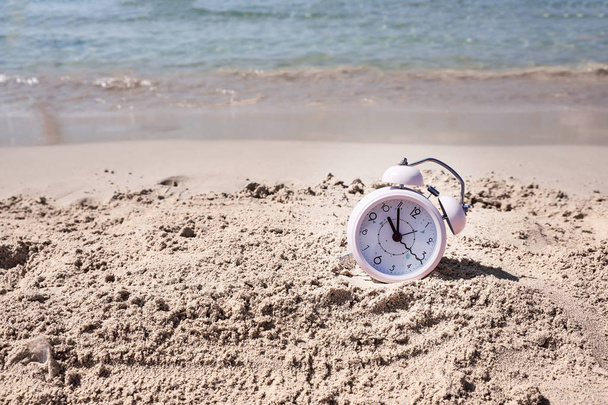 Vacation time. Alarm clock on the sand - Foto, imagen