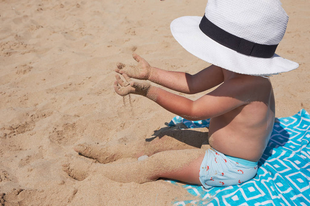 Дитячий спосіб життя на відкритому повітрі. Щасливий милий хлопчик в Панамі грає з піском на морі. Літні канікули та концепція сімейних подорожей. Маленька дитина сидить на піску біля моря
 - Фото, зображення