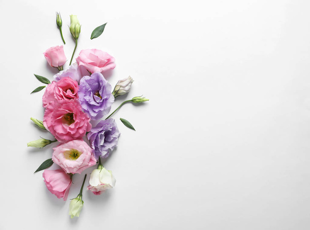 Flat lay composition with beautiful Eustoma flowers on light background - Photo, Image