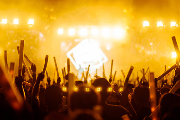 σιλουέτες του χεριού σε συναυλία.Φως από τη σκηνή.confetti.the πλήθος των ανθρώπων σιλουέτες με τα χέρια τους ψηλά - Φωτογραφία, εικόνα