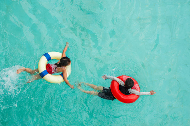 Two children are swimming in the pool with a rubber ring. top vie - Foto, immagini