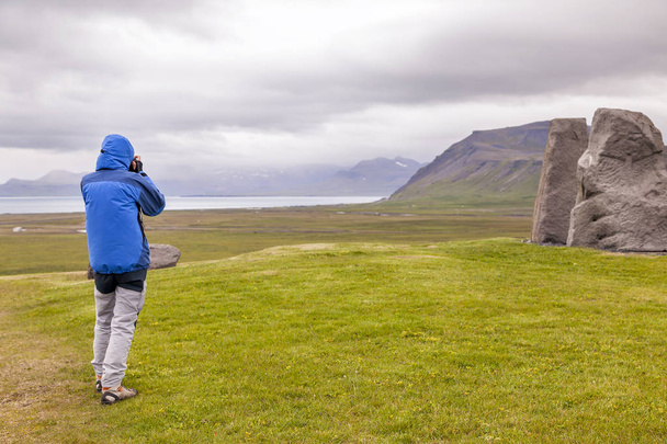 female nature photographer in action in the wild landscape of Snaefellnes peninsula Iceland - Фото, изображение
