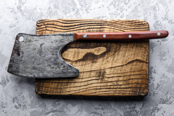 Old rustic axe for meat on a wooden board - Fotó, kép