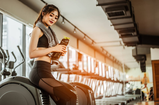 young fitness woman tired in gym drink   protein shake.exercising concept.fitness and healthy lifestyle - Photo, image